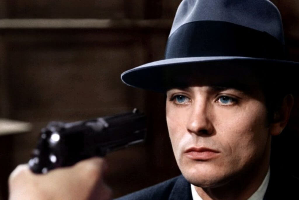 Alain Delon siendo apuntado por una pistola en la película El silencio de un hombre del director francés Jean-Pierre Melville.