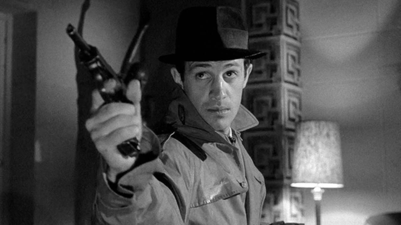 BElmondo, actor referente del cine polar francés, apuntando con una pistola en un fotograma de la película El confidente.